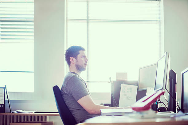 istock Young man sitting at computer desk in office 485602988