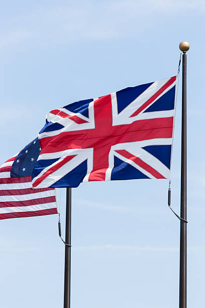 istock British and American flags on flagpoles blowing in the wind. 485607656