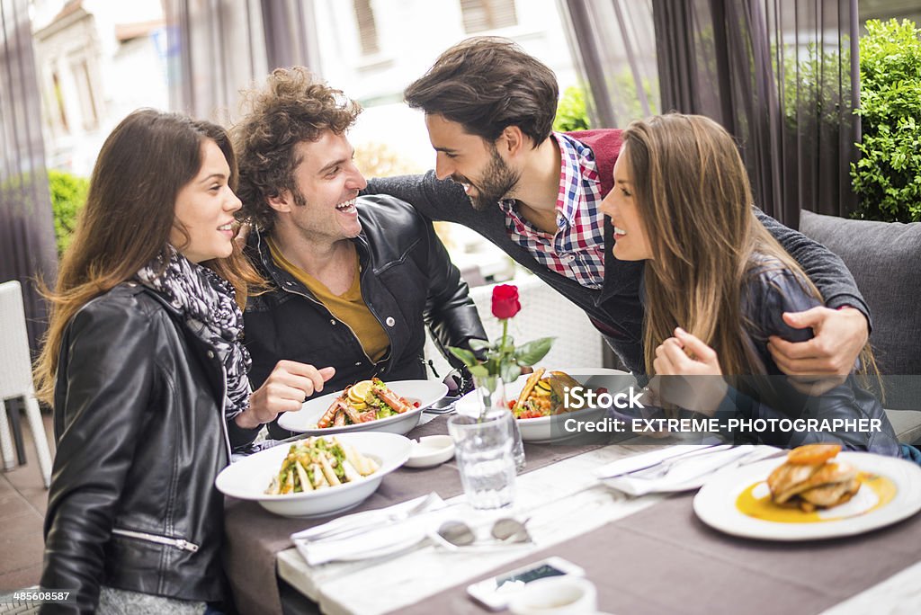 Friends on a double date Young man hugging his friends in the restaurant. Adult Stock Photo