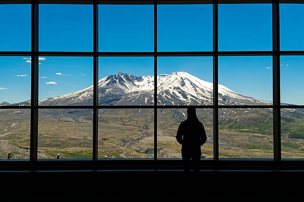 Woman standing in silhouette in front of a picture window at Mount St. Helens National Monument