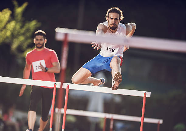 istock Two athletic men competing on a hurdle race. 485610786