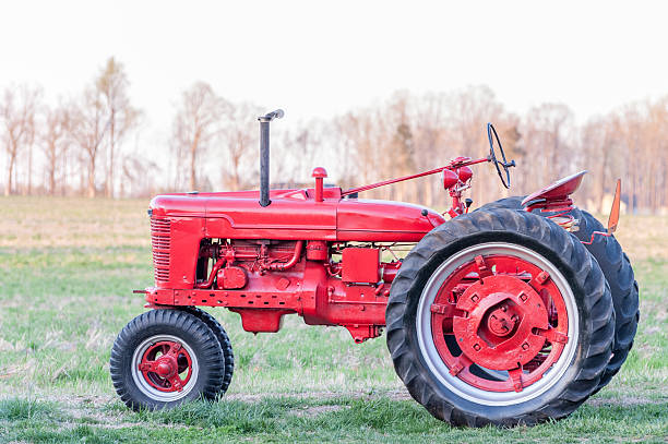 Rouge Antique tracteur au coucher du soleil dans le champ - Photo