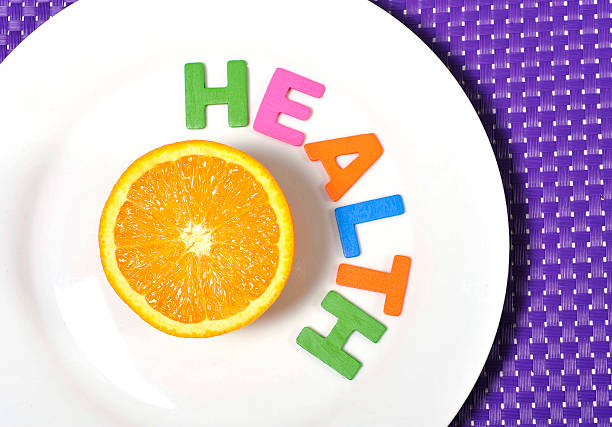 istock Halved fresh  Orange Fruit and health word on plate 485612917