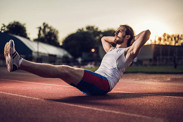 istock Young male athlete doing sit-ups on a stadium. 485614746