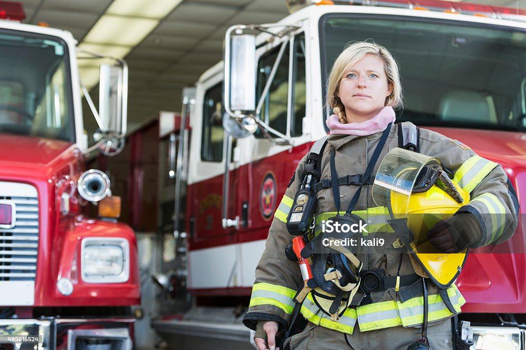 Pompier femme debout en face de camion de pompier - Photo de Pompier libre de droits