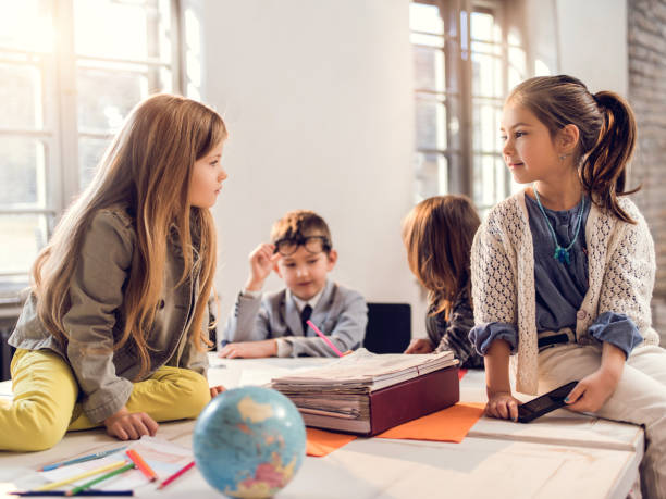 istock Creative little girls sitting on the table and communicating. 485616928