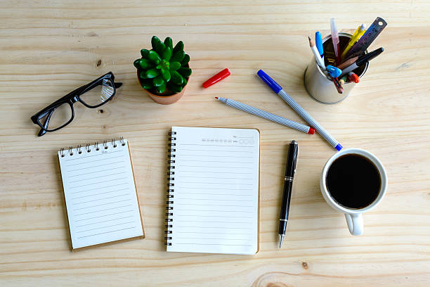 istock Cup of coffee with blank notebook on wooden desk 485619416