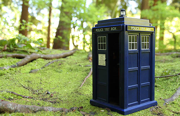 Doctor of the Green Woods Vancouver, Canada - April 11, 2015: A toy TARDIS from the Doctor Who televsion series, in a spring garden. The TARDIS is the Doctor's main form of travel, a time machine and spaceship that is larger on the inside. Doctor Who is created by the BBC. bbc photos stock pictures, royalty-free photos & images