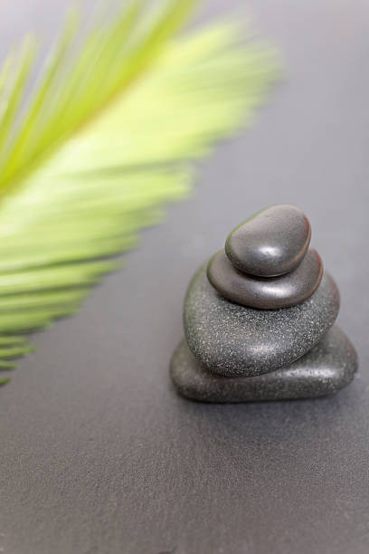 istock Pile of Spa hot rocks with Palm leaf 485622322