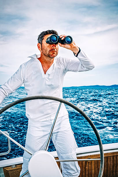 marynarz z lornetki na łódź żaglowa - binoculars surveillance direction looking at view zdjęcia i obrazy z banku zdjęć