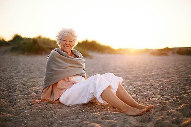 istock Happy old woman relaxing on the beach 485630241