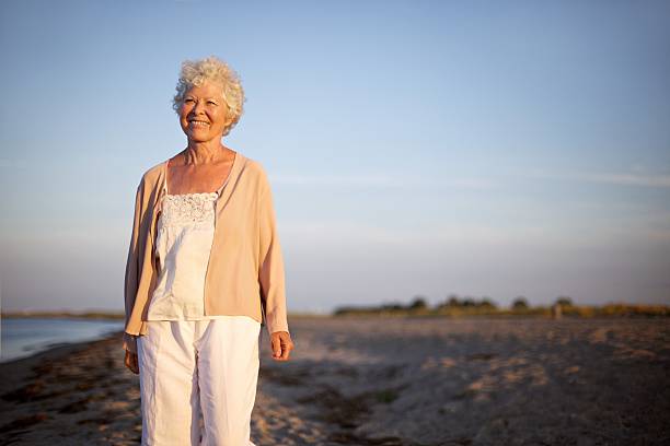 istock Mature woman standing at the beach 485630247