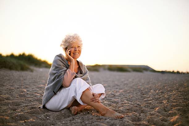istock Retired woman in the beach making phone call 485630251