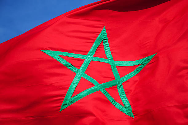 istock National flag of Morocco above blue sky 485631841
