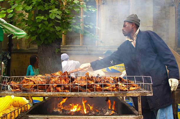 Man cooking jerk chicken at Notting Hill Carnival in London stock photo