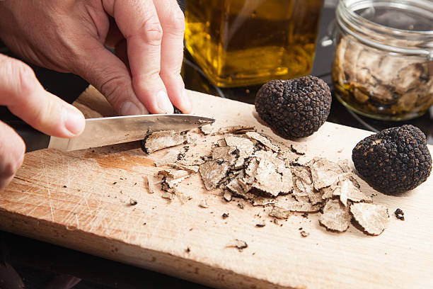 tartufo nero e coltello su sfondo in legno - tartufo foto e immagini stock