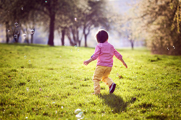 istock Little boy, running in the park, chasing soap bubbles 485635693