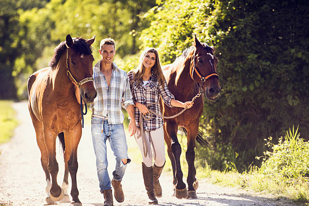 istock Smiling couple walking with horses and looking at camera. 485639530