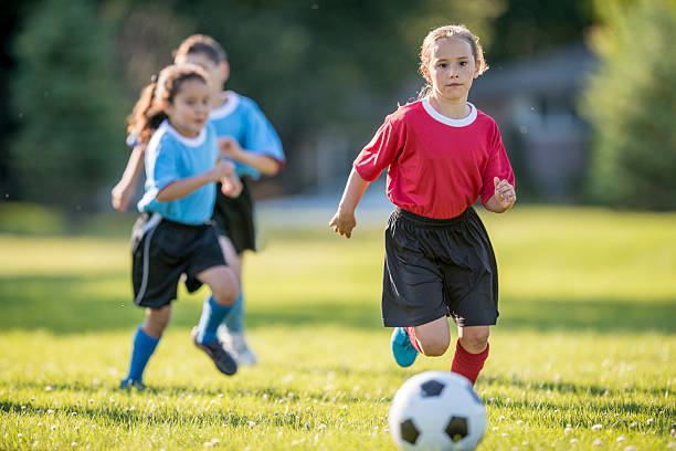istock Girl Chasing a Soccer Ball 485640208