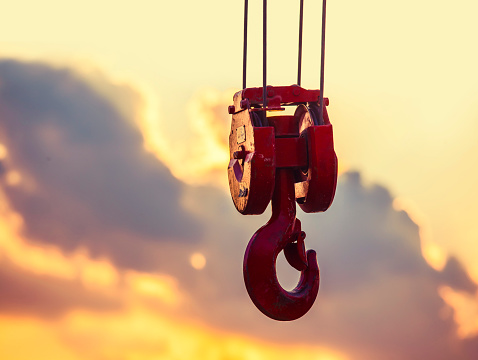 crane hook hanging in the air at sunset