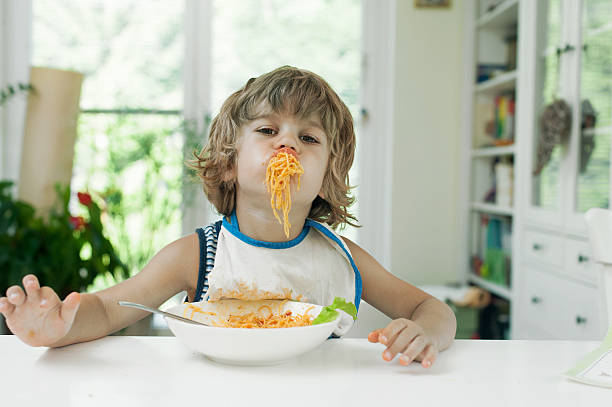 petit garçon faire des choses - child eating pasta spaghetti photos et images de collection