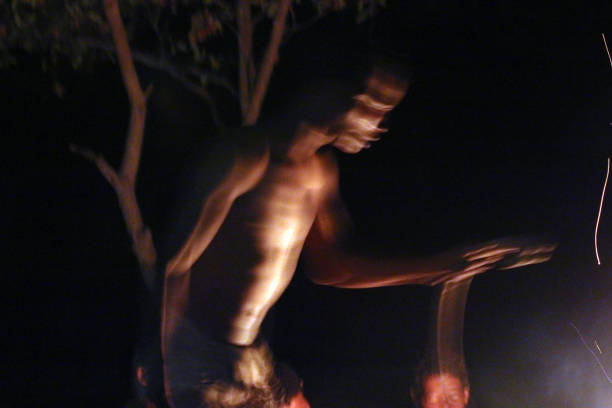 Ghanzi, Botswana - March 24, 2012: A man from a group of Bushmen of the Kalahari dances around the fire.