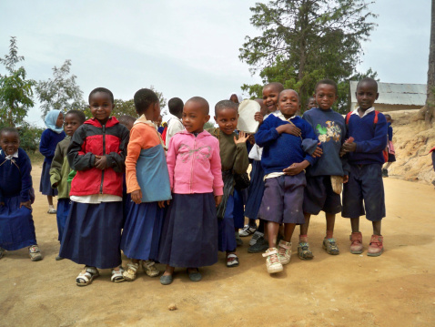 Soni Village, Tanzania - January 3, 2008: Cheerful school children standing outside during a lunch break