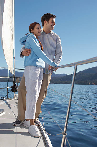 istock Couple Standing on Side of Sailboat 485655501