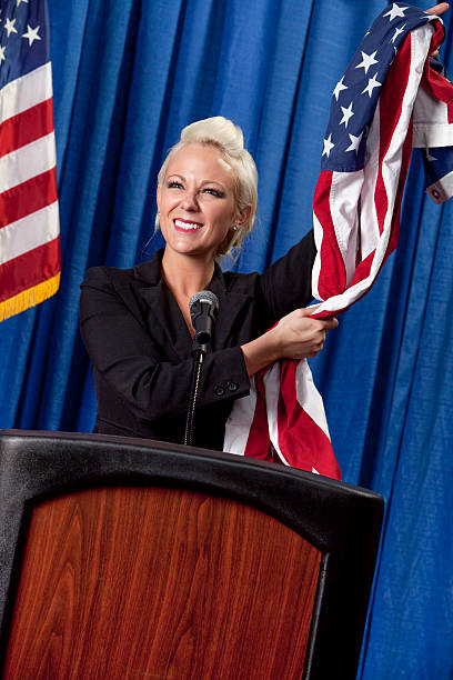 istock Female Politician holding American Flags 485656165