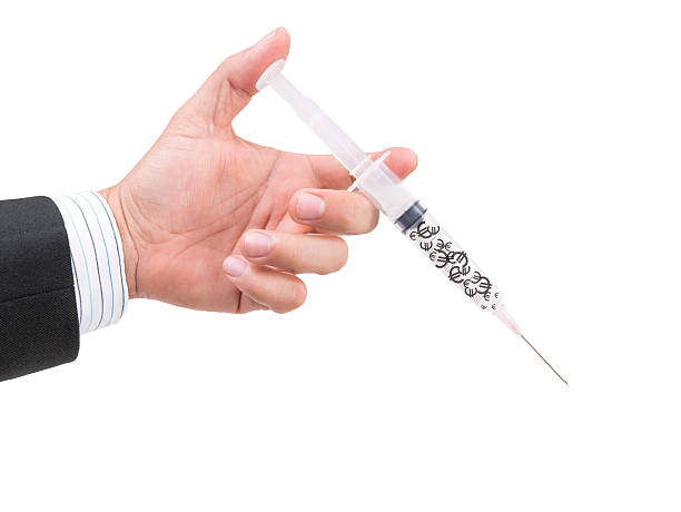 istock hand holding syringe filled with currency 485656780