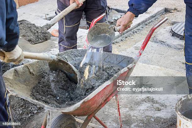 Los Trabajadores De Mezclar El Cemento A Mano En Carretilla 2 Foto de stock y más banco de imágenes de Adulto