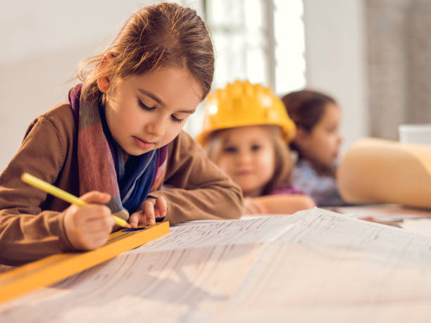 istock Little girl architect working on blueprints in the office. 485671178