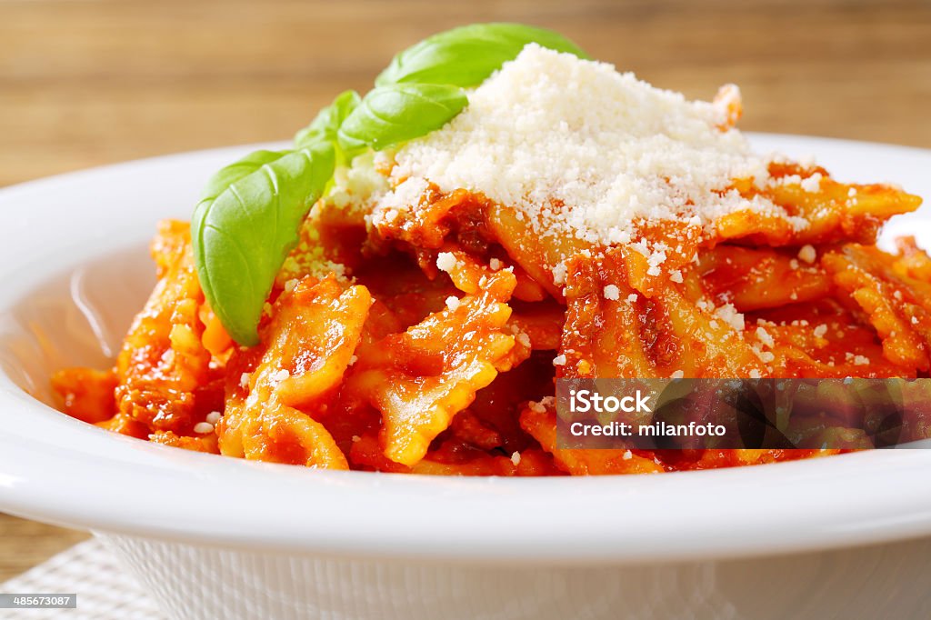 tomato farfalle detail of farfalle pasta with tomato sauce and grated parmesan in white plate Basil Stock Photo