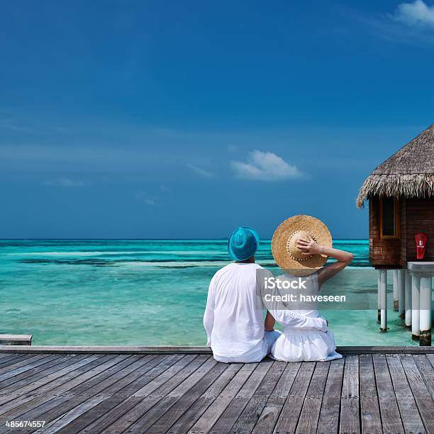 Couple On A Beach Jetty At Maldives Stock Photo - Download Image Now - Couple - Relationship, Maldives, Beach