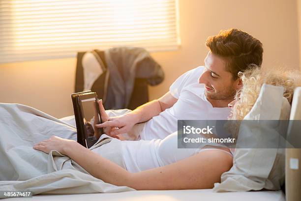 Couple Using A Digital Tablet Stock Photo - Download Image Now - 25-29 Years, Adult, Adults Only