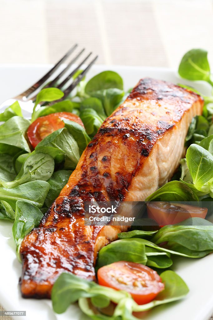 Grilled salmon with a honey glaze Grilled salmon with a honey glaze on a bed of lambs lettuce Glazed Food Stock Photo