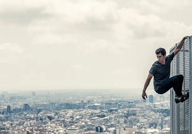 Urban parkour Man climbing fence