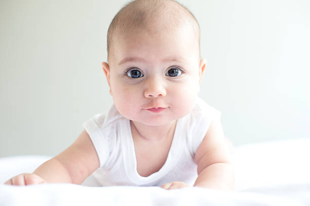 Beautiful Baby on White Towel Beautiful baby on white towel is looking at camera, horiztonal 8 weeks stock pictures, royalty-free photos & images