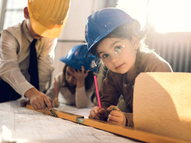 istock Small group of little engineers working on blueprints. 485684772