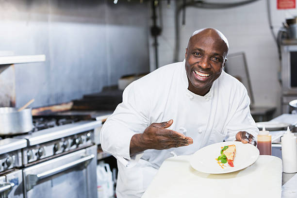 noir chef dans un restaurant tenant une assiette à dessert - chef restaurant cooking african descent photos et images de collection