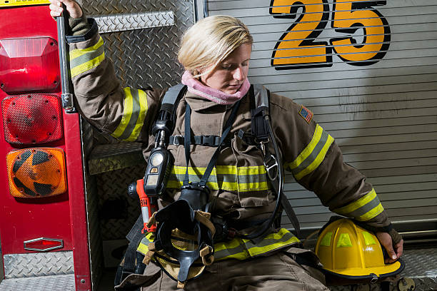 istock Female firefighter sitting on fire rescue truck 485691406