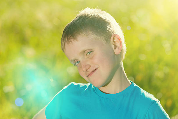 Smiling boy on a blurred background of trees. Portrait of a smiling 9 year old boy in a blue t-shirt in the garden