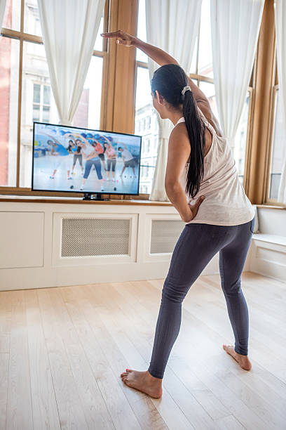 istock Woman exercising at home watching tv 485693304