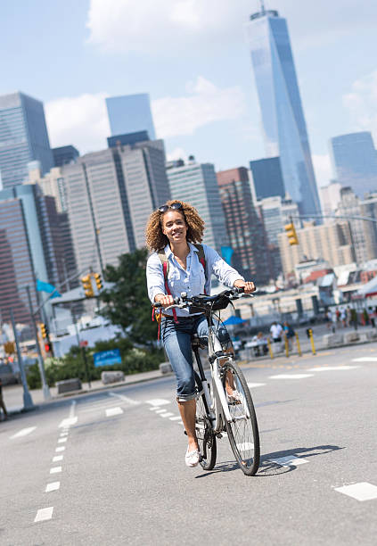 Happy African American woman riding a bicycle on the street in New York on a summer day