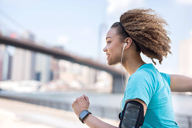 運動の女性屋外でのランニング  - arm band ストックフォトと画像