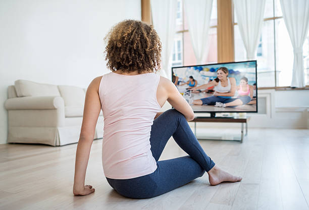 mujer en forma haciendo ejercicio en casa viendo un dvd - dvd fotografías e imágenes de stock