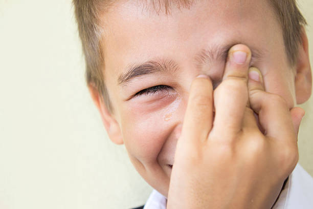 Little boy crying,also laughing against colored background Little boy crying,also laughing against colored background. Child weeping for joy. Boy laughing while he crying. Horizontal compostion. Image developed from Raw format. wiping tears stock pictures, royalty-free photos & images