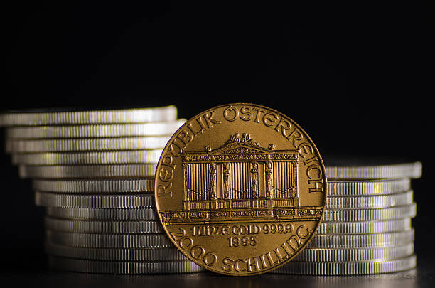 Austrian Philharmonic Gold Coin infront Silver Coins Austrian Philharmonic Gold Coin infront Silver Coins gold and silver coins for sale stock pictures, royalty-free photos & images