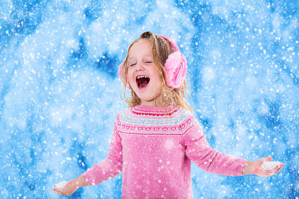 istock Little girl catching snow flakes 485715096