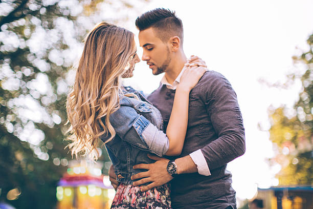istock Young couple embracing in luna park. 485715556